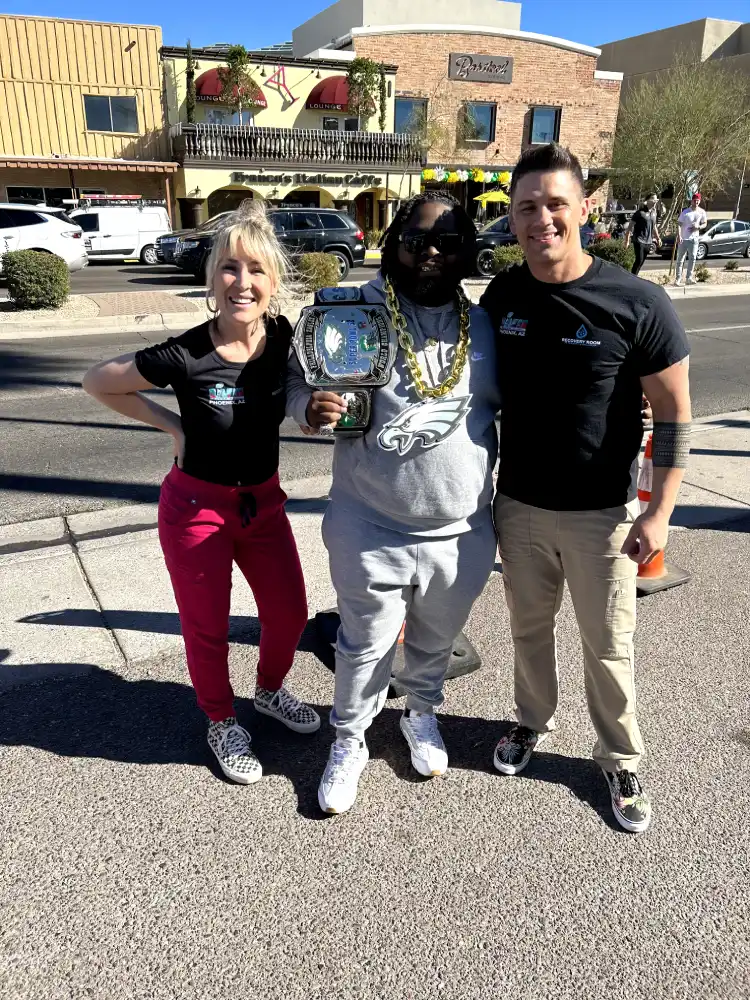 Recovery Room team members with a championship belt at a Scottsdale sports event